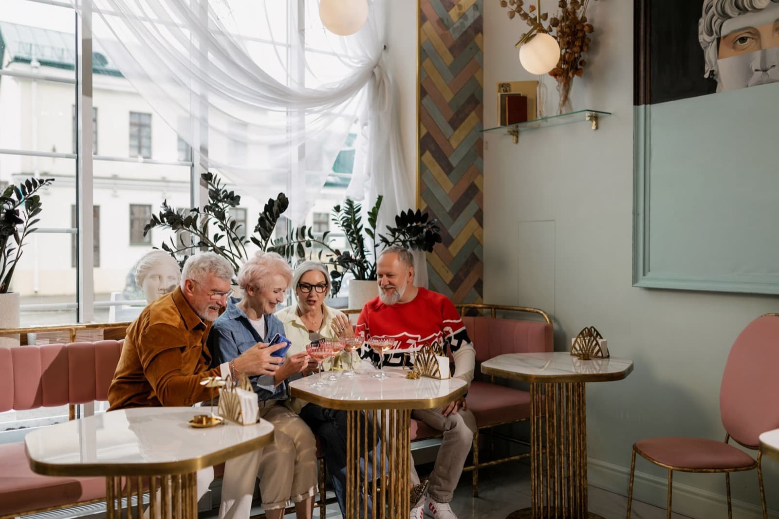 Een groepje mensen zit lachend samen aan een cafétafel