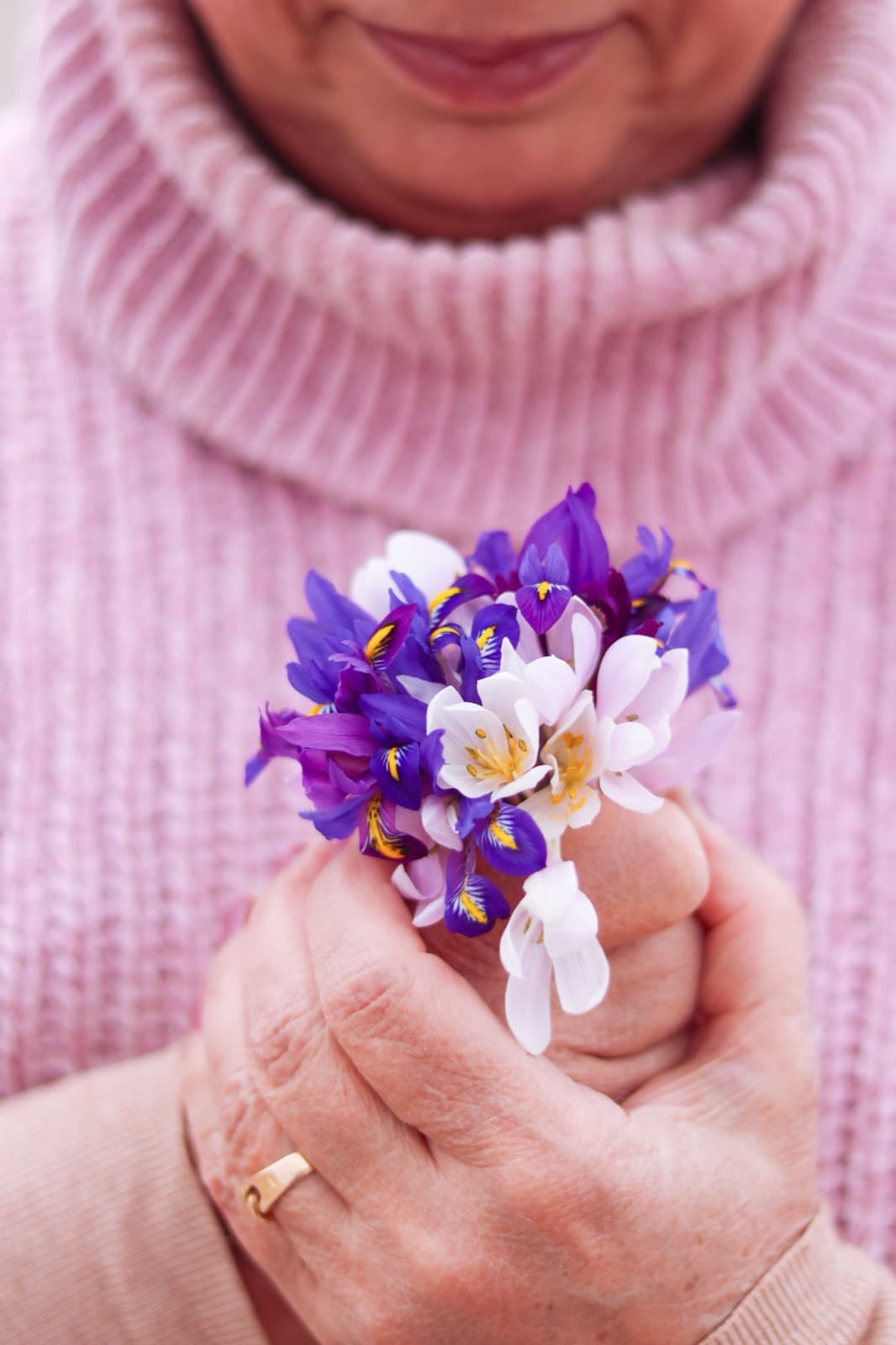 Een vrouw houdt een klein boeketje voorjaarsbloemen in haar handen